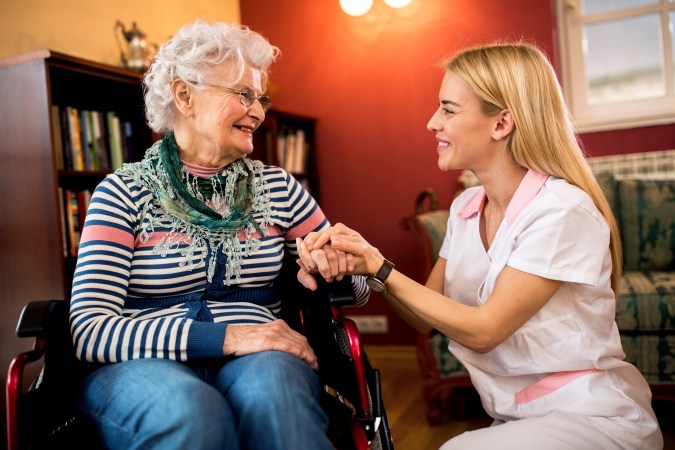 Young patient nurse console senior woman in wheelchair